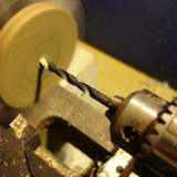 A hole was drilled in the door, also on the lathe, so that I could fix the knob in place with a small screw from the back.