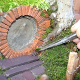 I had built a slate path up from the gate to the front door, with a little paved area extending under the window. The cracks and gaps between the slabs were filled in with little tufts of moss.